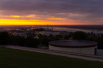 Beautiful panoramic cityscape of downtown district of Volgograd city in Russia during romantic sunrise. Orange sky and dark clouds. Soft focus. Viewpoint on Mamayev Hill. City landscape theme.