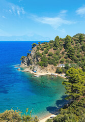 Aegean sea coast landscape with aquamarine water and Mount Athos in mist (Chalkidiki, Greece). Three shots stitch image. People unrecognizable.