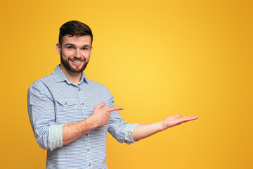 A man extending his hands outward in a gesture of offering or reaching out, holding them up with...