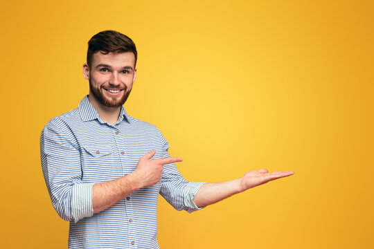 A man extending his hands outward in a gesture of offering or reaching out, holding them up with palms facing forward, copy space