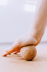 Close up of hand doing palm fascia release exercise with cork ball