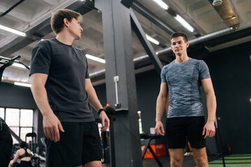 Low-angle view of professional personal trainer explaining correct execution of exercise for...
