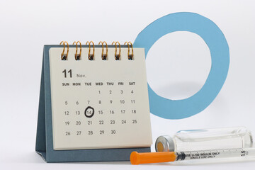 Calendar with the world diabetes day marked and a syringe and a insulin vial 
