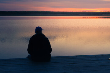 man sitting outdoors enjoying the sunset, man relax siting on pier