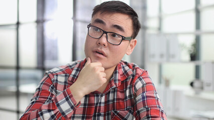 Obraz premium a young investor in casual clothes sits at a table and thinks about profit