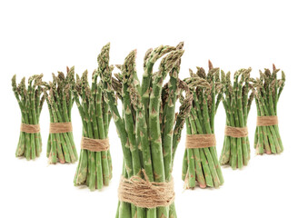 seven clusters of uncooked green asparagus tied with string
