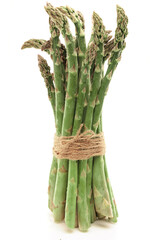 fresh asparagus with water drops tied with string on white background