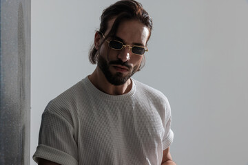 cool bearded man with long hair wearing sunglasses and looking forward