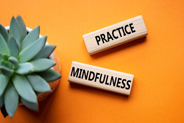 Practice Mindfulness symbol. Concept words Practice Mindfulness on wooden blocks. Beautiful orange...