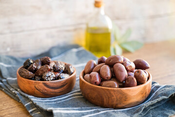 Olives in wooden bowl and olive oil