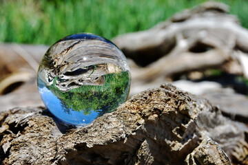 A creative image of a photographic lens ball reflecting an inverted image of an old knotted...