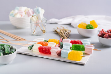 Gummy candy kabobs on skewers served on the table