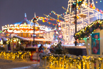 Defocused colorful merry-go-round on Christmas Fair in winter with lots of lights and bokeh on...