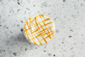 A top down view of a coffee drink with cream and caramel drizzle.