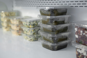 A view of several pre-made entree packages on a commercial refrigerator shelf, seen at a local...