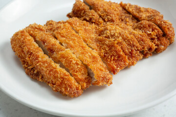 A closeup view of a plate of sliced chicken katsu.