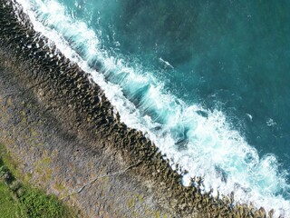 Rocky shore if a beach in San Andres Island, Colombia. The waves crushes against the shore and produce white foam and beautiful patterns