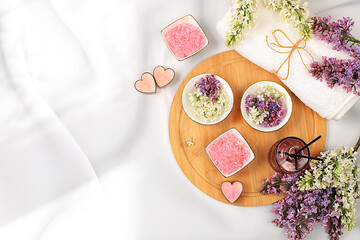 Fragrant pink salt, lilac water and lilac flowers. Spa and wellness composition, aromatherapy and...