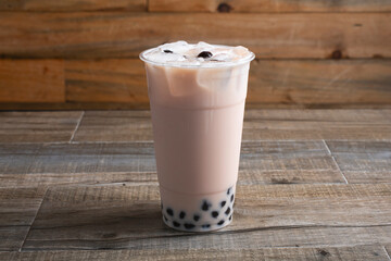 A view of a rose jasmine milk tea drink, with boba.
