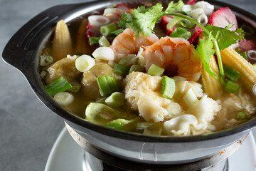 A closeup view of a pot of wonton soup, Thai style.