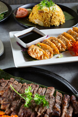 A view of a plate of fried dumplings, among other Asian entrees.