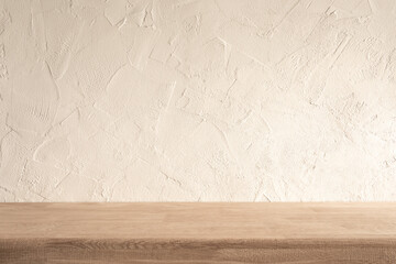 A clean, minimalist wooden kitchen counter against a textured off-white wall in a bright daytime...