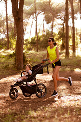 Beautiful young woman runs with a stroller.