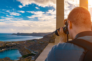 Man takes a photograph of Saint Pauls Bay.