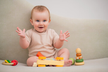A baby is sitting on a couch with a toy truck in front of him.