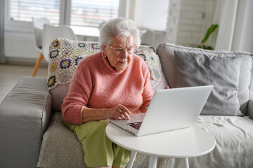 Online scams targeting seniors. Scammer sending email to elderly woman, asking for money, demanding...