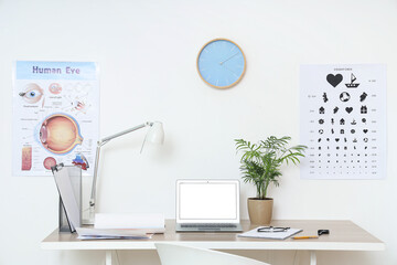 Interior of ophthalmologist's office with workplace and eye test chart