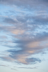 Sky at dusk, light blue sky with clouds in white, blue, and gray, as a nature background
