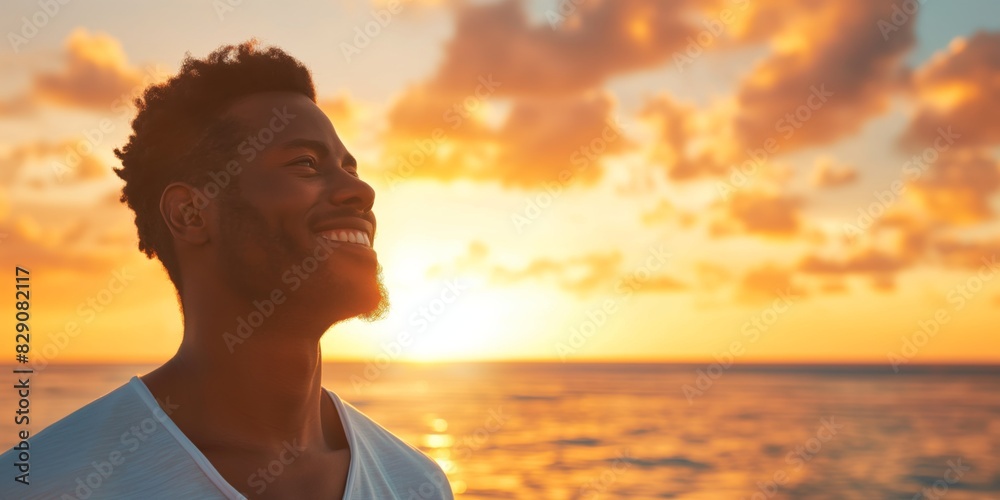 Wall mural excluding the blurred face, the image captures a man from behind looking out at a stunning ocean sun