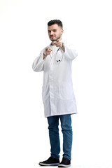 The doctor, in full height, on a white background, points forward