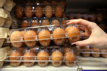 A person is reaching for a carton of eggs