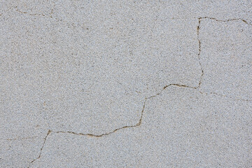 A grey and white wall with a crack in it
