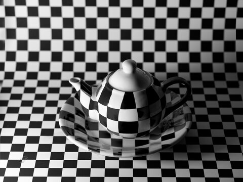 Close-up of a checked teapot, plate and background