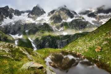 Snowcapped mountain peaks reflected in an alpine lake, Susten Pass, Switzerland