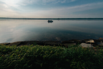 Obraz premium A pontoon boat out on a misty morning along the Saint Lawrence River.