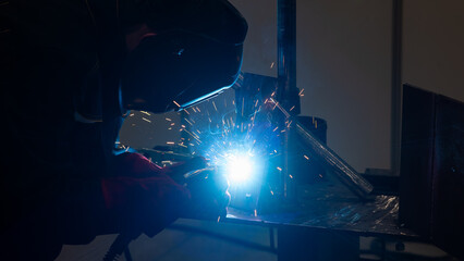 Competitions among welders. A man in a protective mask is welding.