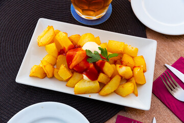 Spicy potatoes with garlic sauce, popular Spanish dish Patatas bravas