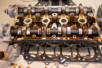 Dirty engine head on tiled floor with scattered parts