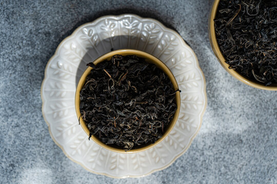 Overhead view of two Ceramic bowls filled with loose leaf tea on a table
