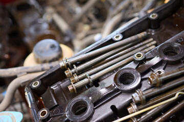 Dirty engine head on tiled floor with scattered parts