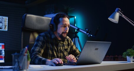 Remote employee writing important emails at home office desk while listening music, finalizing deal...