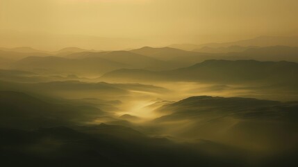 Obraz premium The rugged outline of a mountains shadow ting through a sea of mist during daybreak.