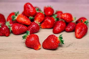 Fresh delicious selected strawberries on a brown wooden table