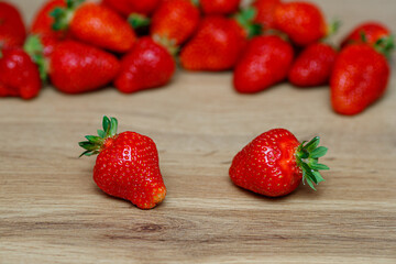 Fresh delicious selected strawberries on a brown wooden table