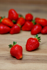 Fresh delicious selected strawberries on a brown wooden table
