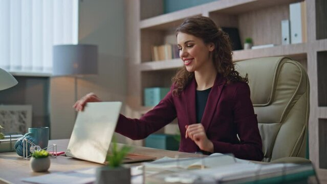 Joyful woman finishing project in agency office. Smiling businesswoman closing